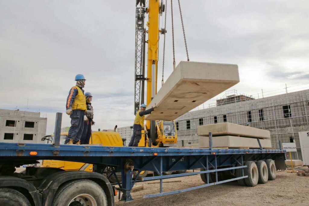 Mobile crane lifting heavy construction materials at an industrial worksite
